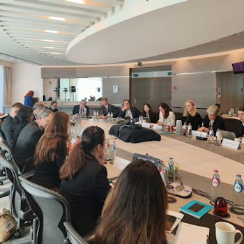 people sat around a board table having a meeting